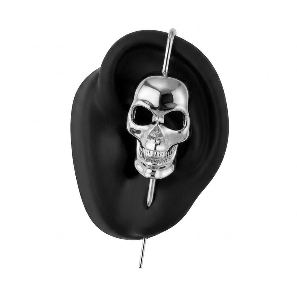 Memento Mori ear cuff in silver on a black ear form