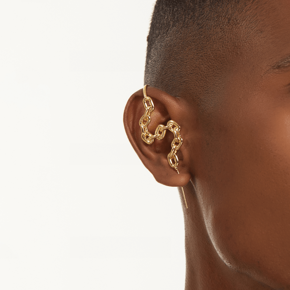 Chain-Link ear cuff in gold worn on the ear, profile view