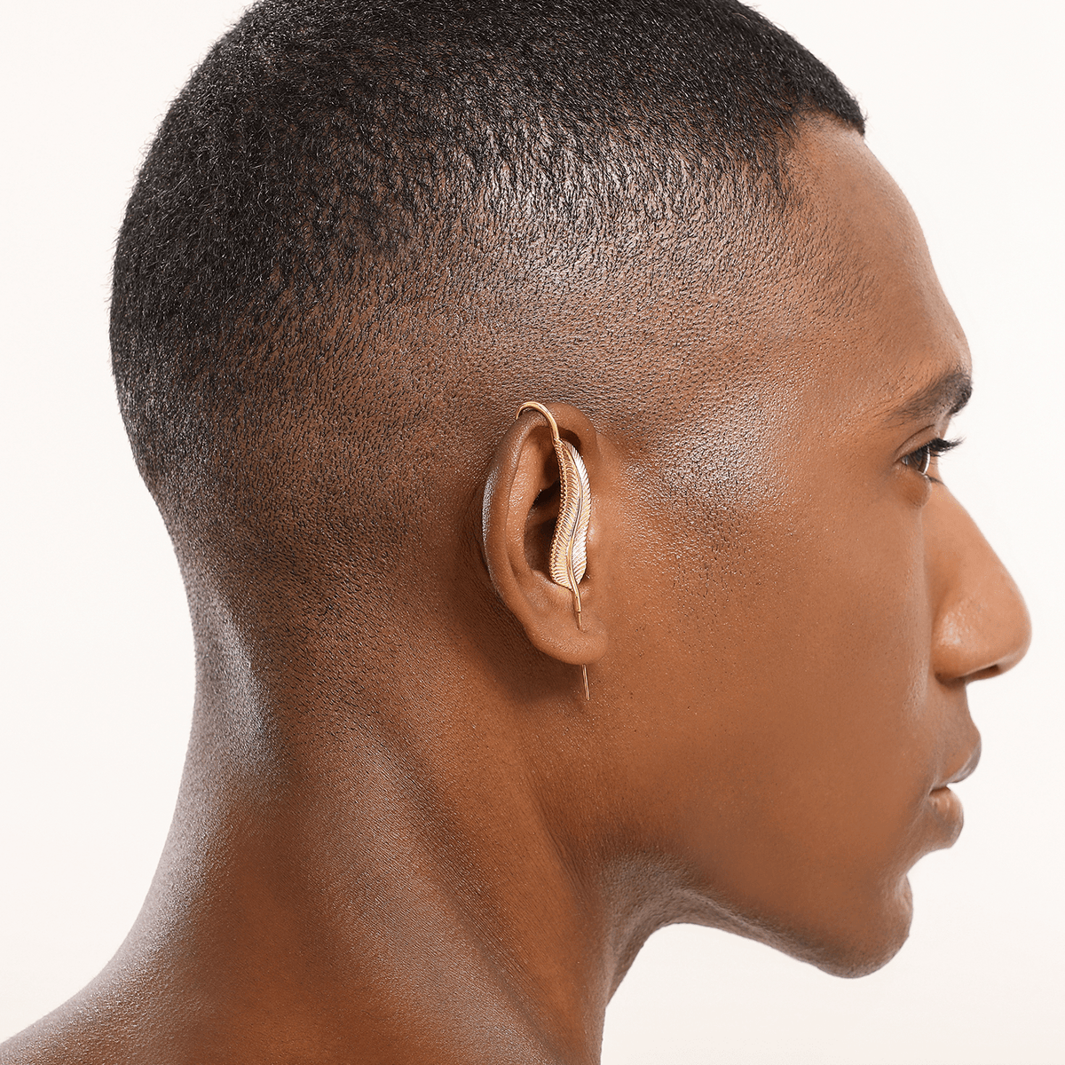 Feathered Grace ear cuff in gold worn on the ear, profile view