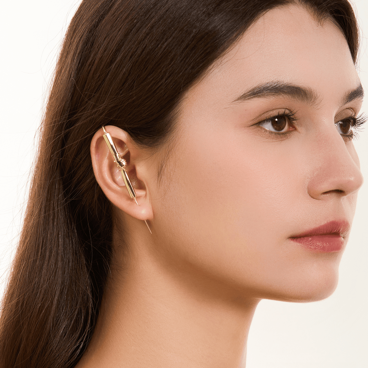 Helping Hand ear cuff in gold worn on the ear, profile view