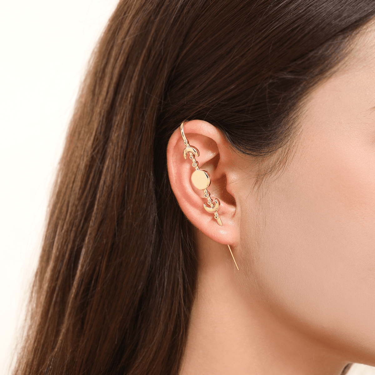 Moon Phases ear cuff in gold worn on the ear, profile view