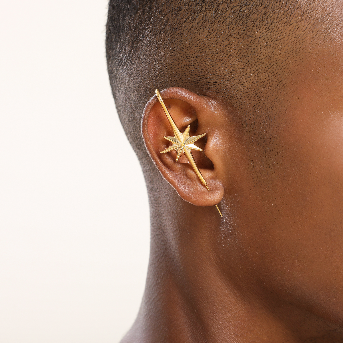 North Star ear cuff in gold worn on the ear, profile view