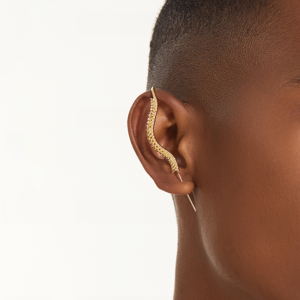 Spine-Chilling ear cuff in gold worn on the ear, profile view