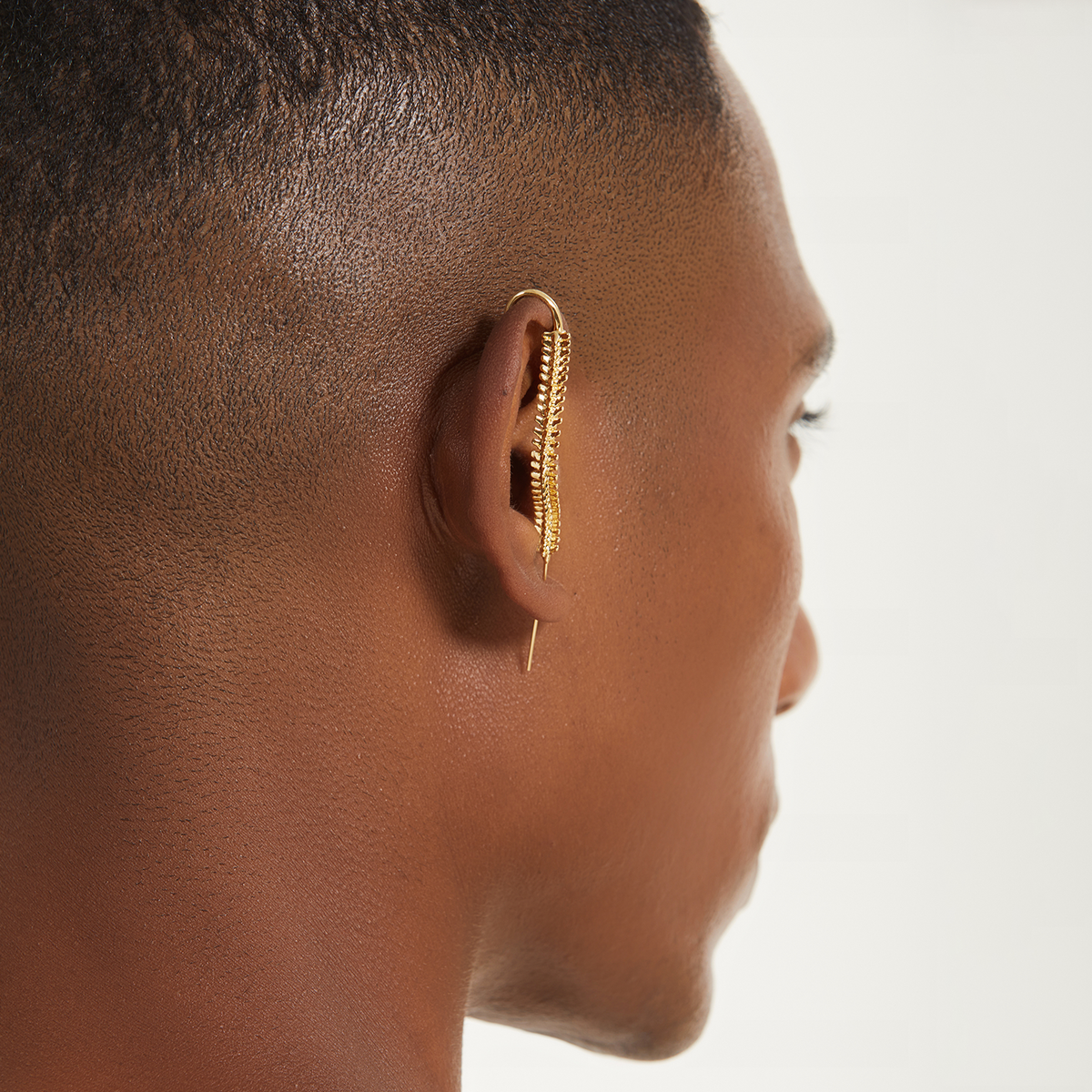 Spine-Chilling ear cuff in gold worn on the ear, profile view
