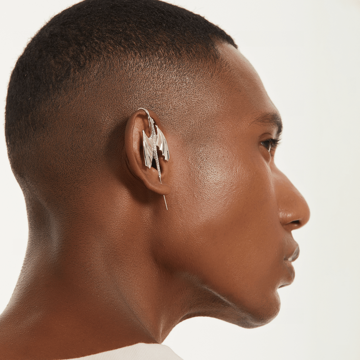 Stormscale ear cuff in silver worn on the ear, profile view
