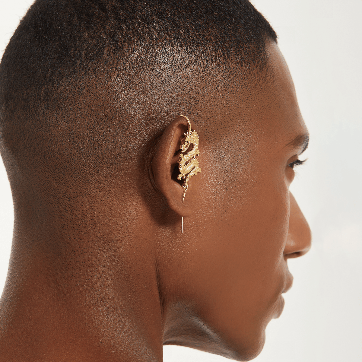 Tianlong 天龙 ear cuff in gold worn on the ear, profile view