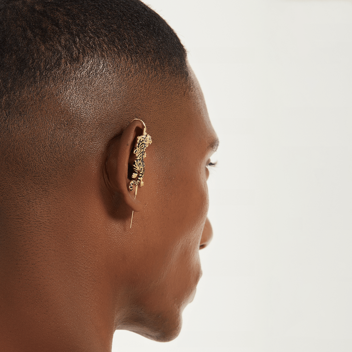 Prowling Tiger ear cuff in gold worn on the ear, profile view