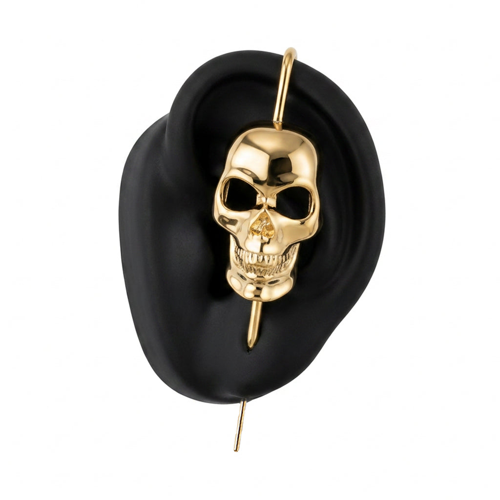 Memento Mori ear cuff in gold on a black ear form