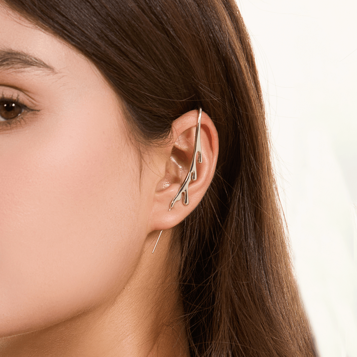 Drip ear cuff in silver worn on the ear, profile view