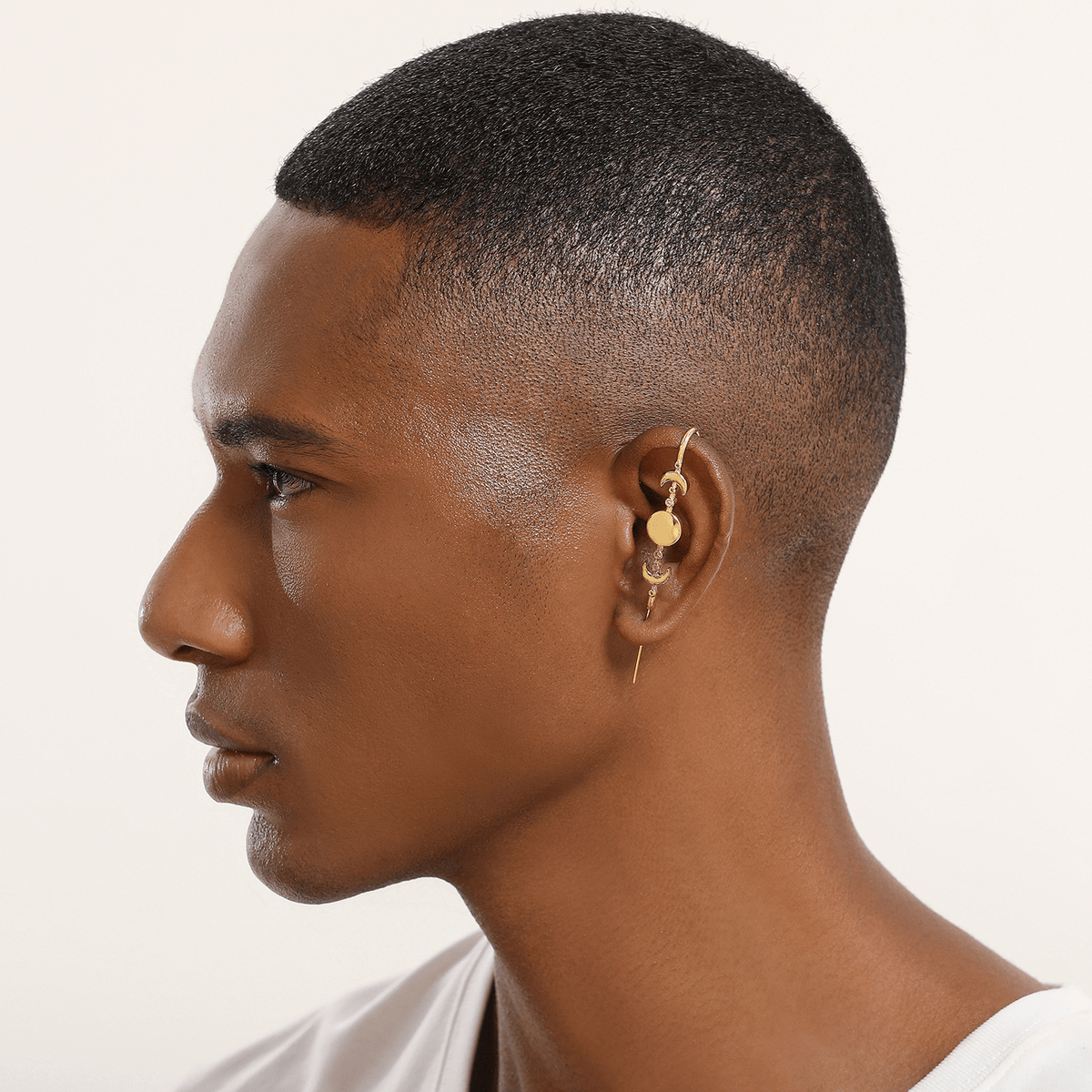 Moon Phases ear cuff in gold worn on the ear, profile view