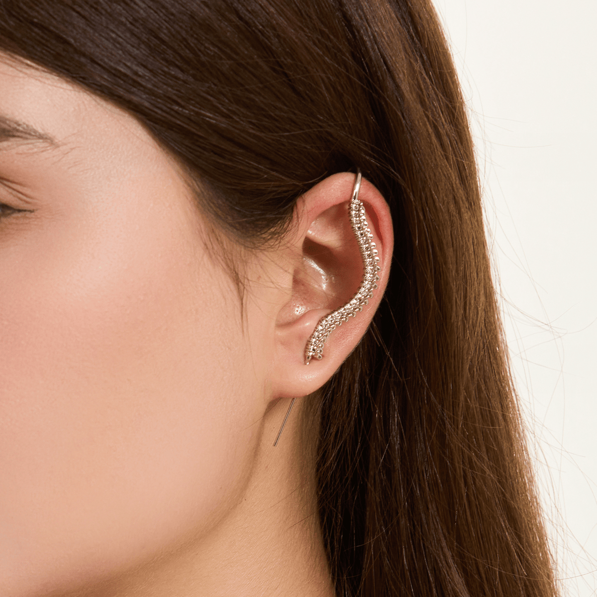 Spine-Chilling ear cuff in silver worn on the ear, profile view