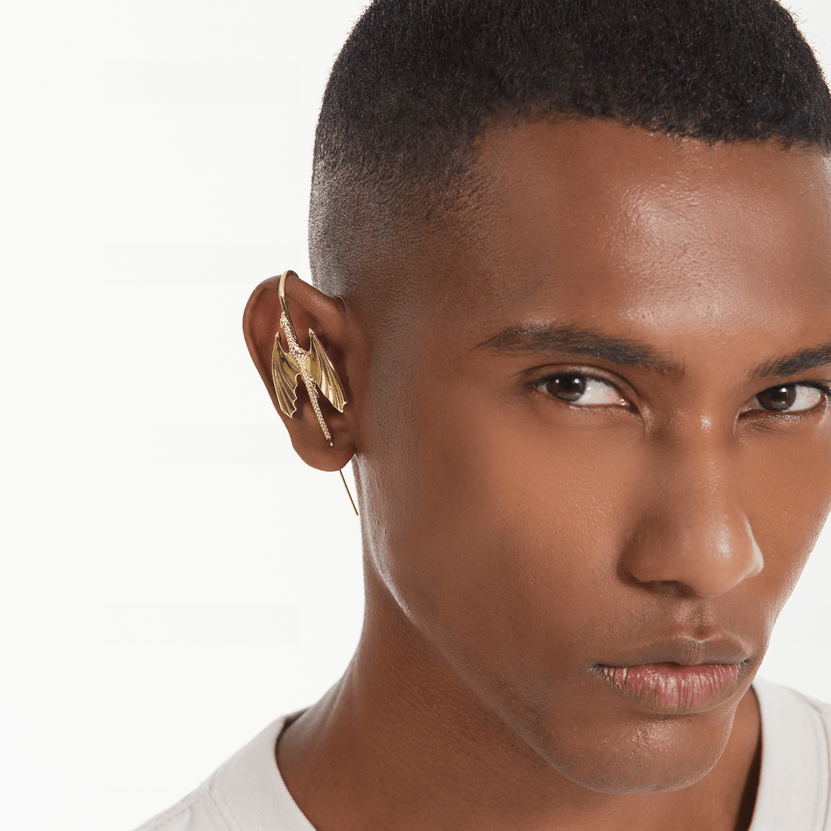 Stormscale ear cuff in gold worn on the ear, profile view