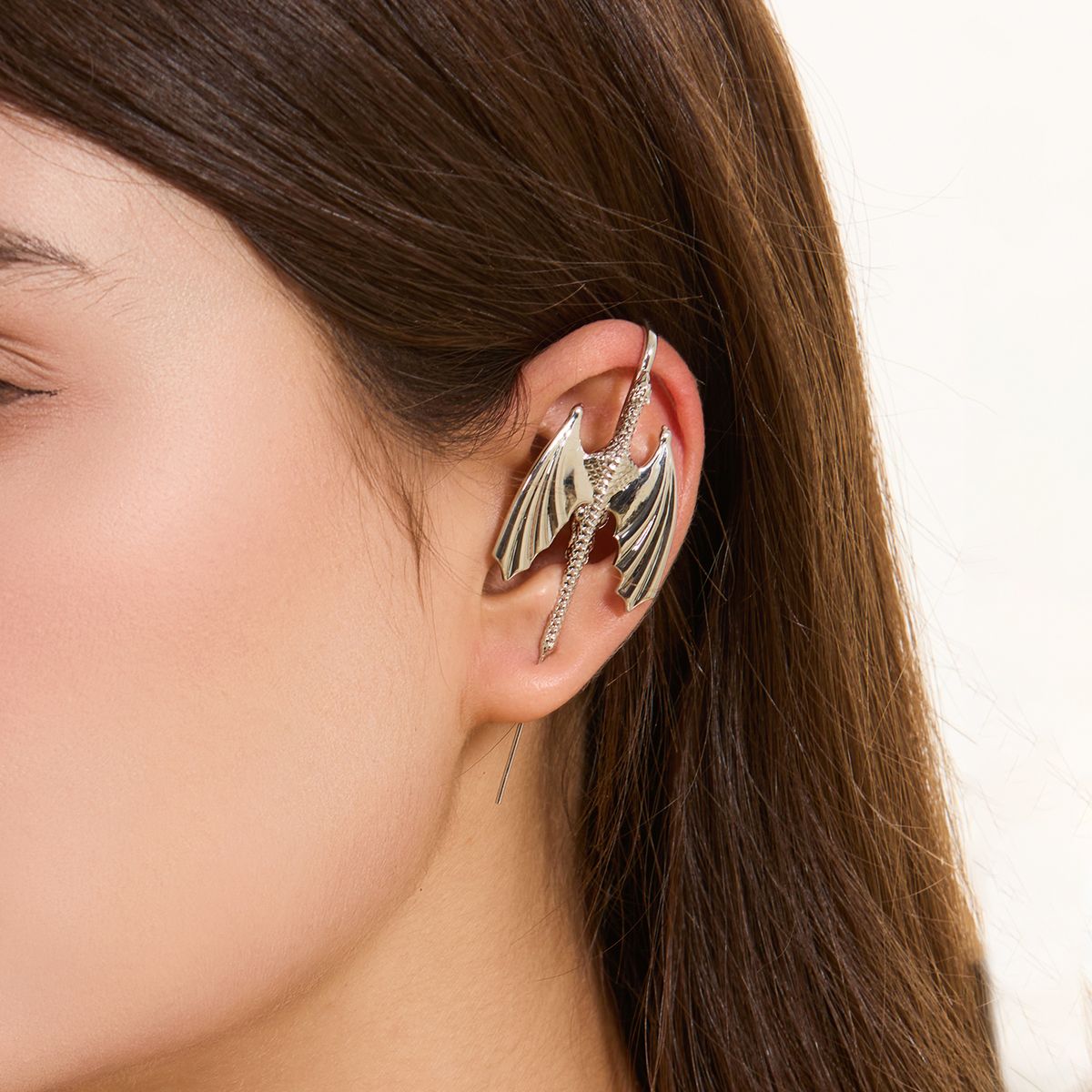 Stormscale ear cuff in silver worn on the ear, profile view