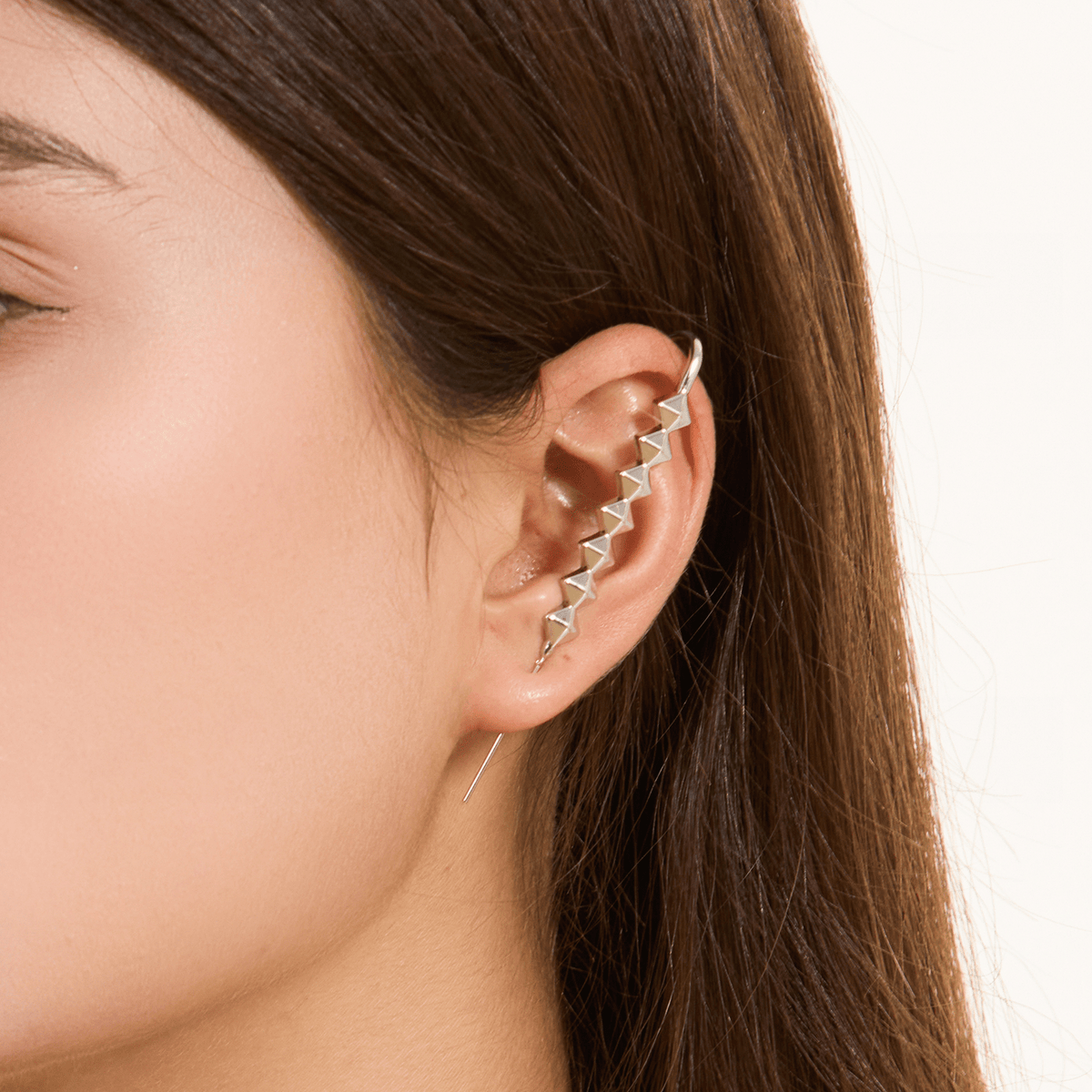 Studded ear cuff in silver worn on the ear, profile view