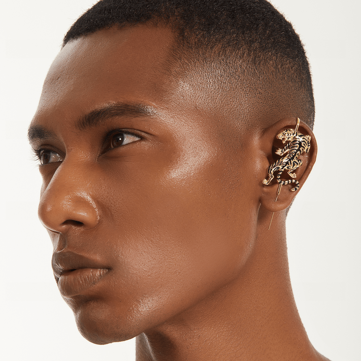 Prowling Tiger ear cuff in gold worn on the ear, profile view