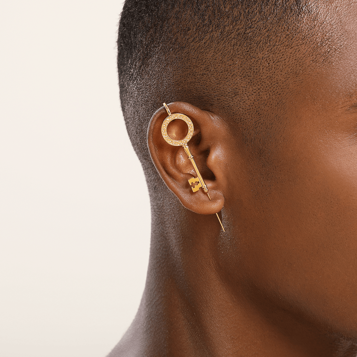 Unlocked Potential ear cuff in gold worn on the ear, profile view